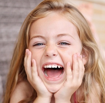 child smiling and missing a tooth